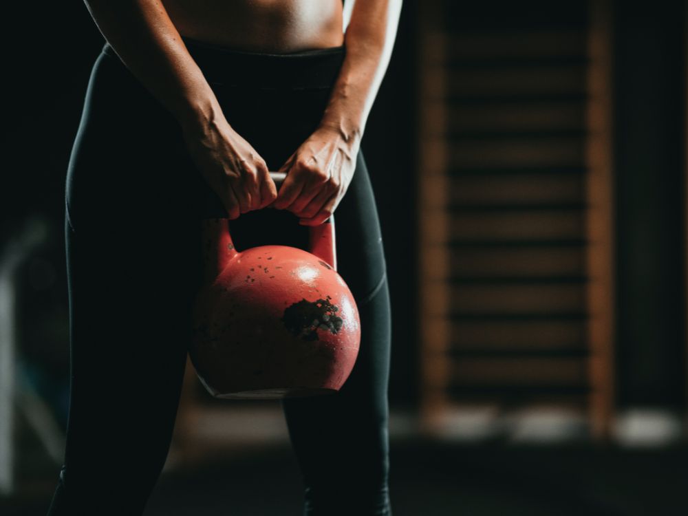 Homem carregando caixas durante mudança residencial com apoio de outra pessoa ao fundo.